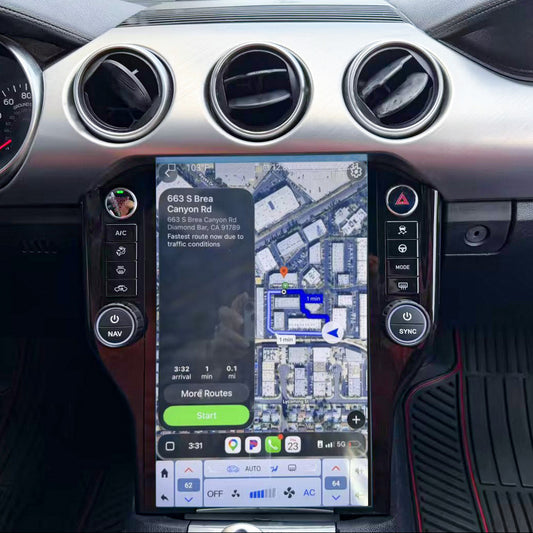 A close-up of a car's dashboard featuring a large vertical touchscreen display showing a navigation map, with silver circular vents and black interior trim.