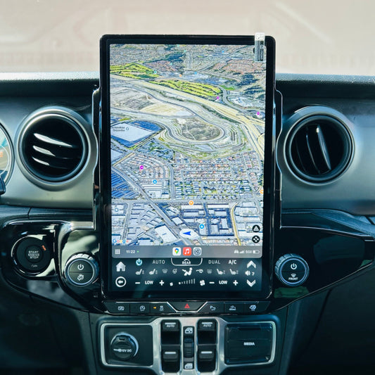 An image showing a 14.5” vertical touchscreen Android navigation radio installed in the dashboard of a vehicle interior, specifically in a Jeep Wrangler.